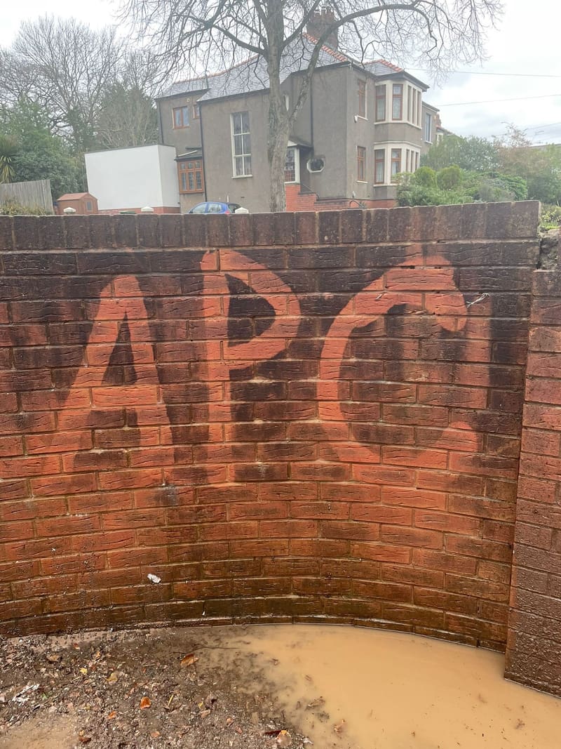APC lettering on a curved brick wall