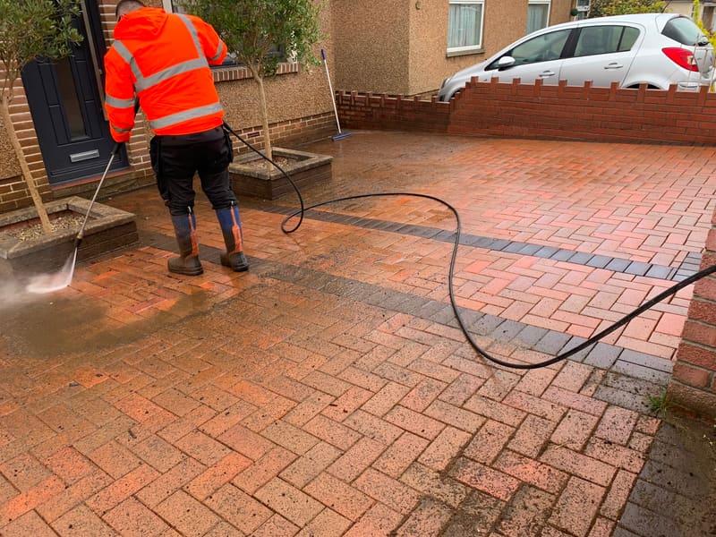 Pressure washing a brick driveway