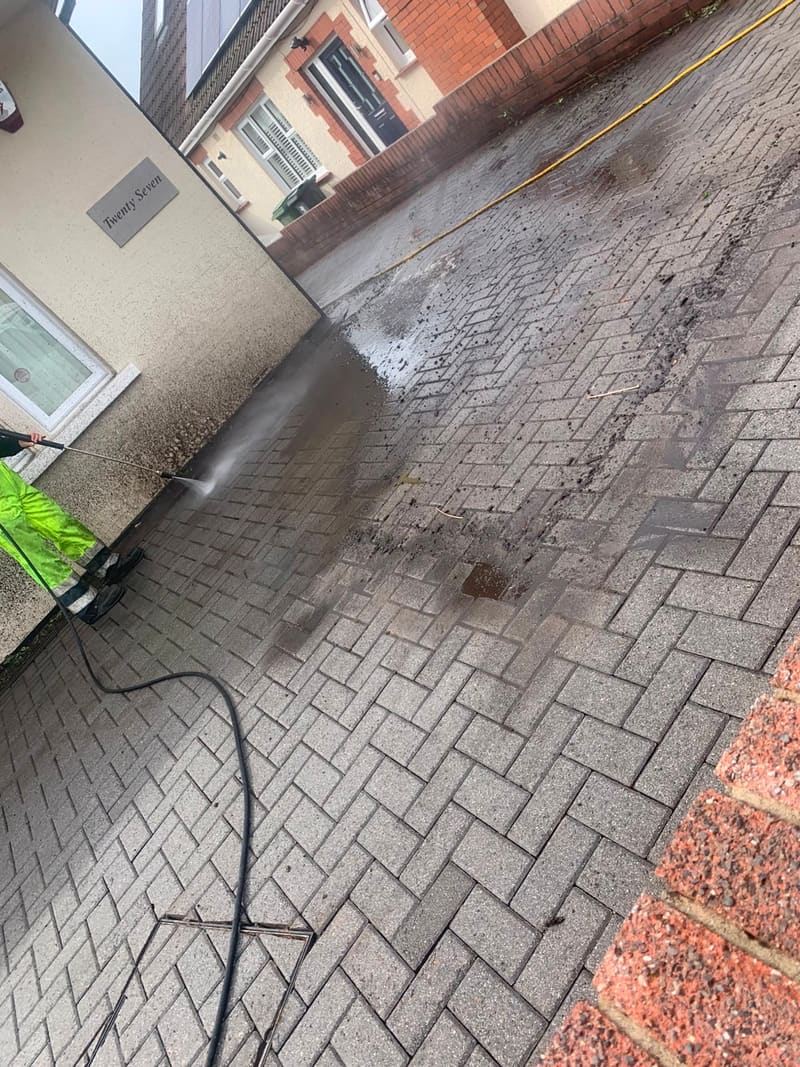 Pressure washing a dirty block paved driveway