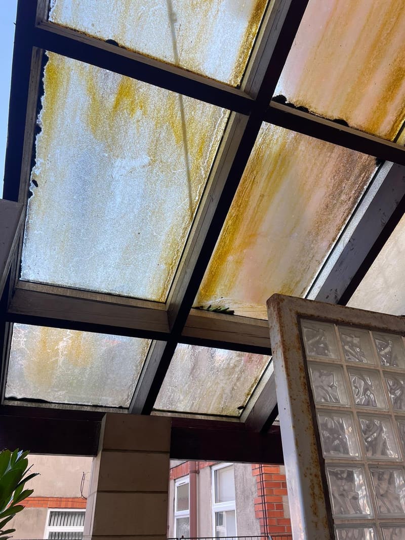 Dirty, stained glass skylight in a metal frame before cleaning
