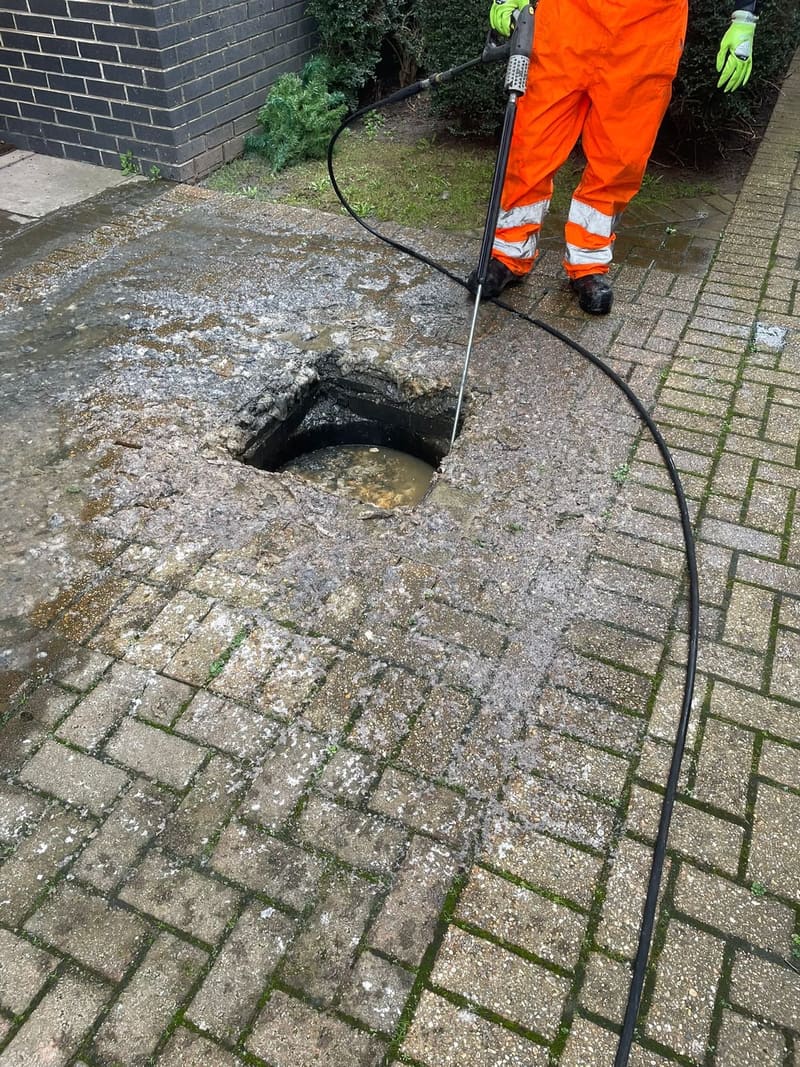 Jetting a blocked drain on a brick driveway