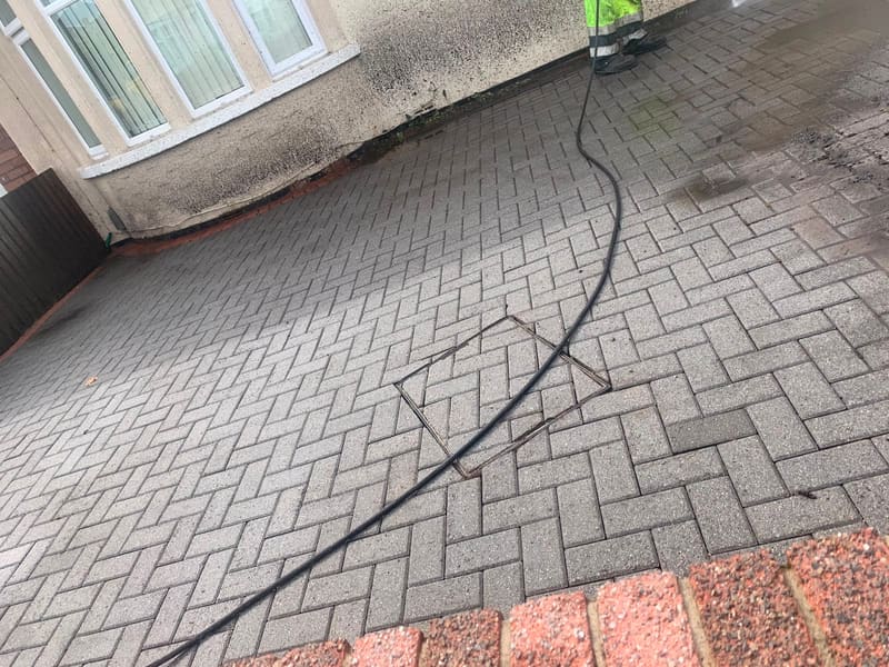 Pressure washing a brick driveway