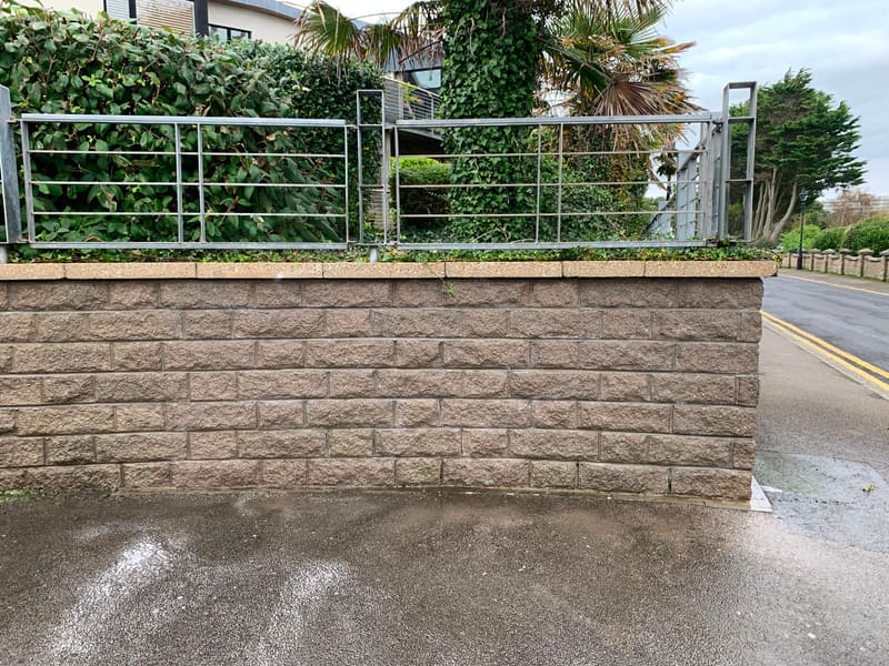 Textured stone retaining wall with metal railing