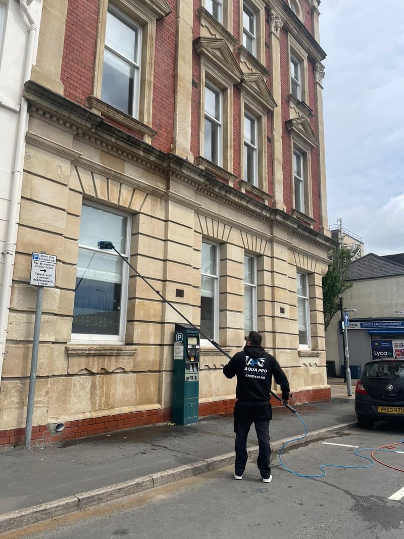 Aqua Pro cleaner using a reach pole on a brick commercial building