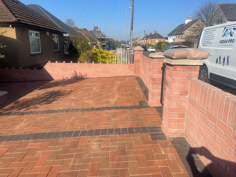 Clean red block paved driveway with matching garden walls